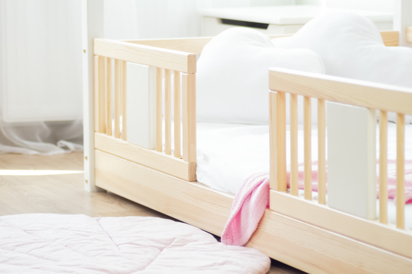 Rodzic czytający dziecku przed snem w drewnianym łóżku dziecięcym